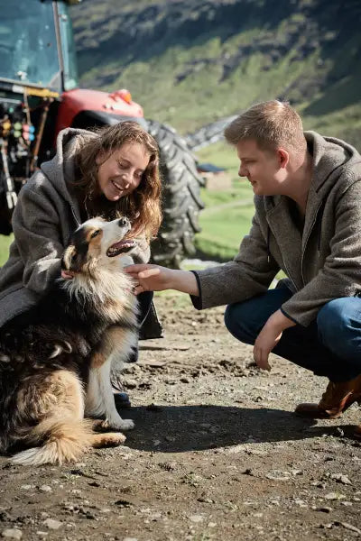 Junges Paar mit Hund auf den Färöer Inseln mit Hoodie Eivind